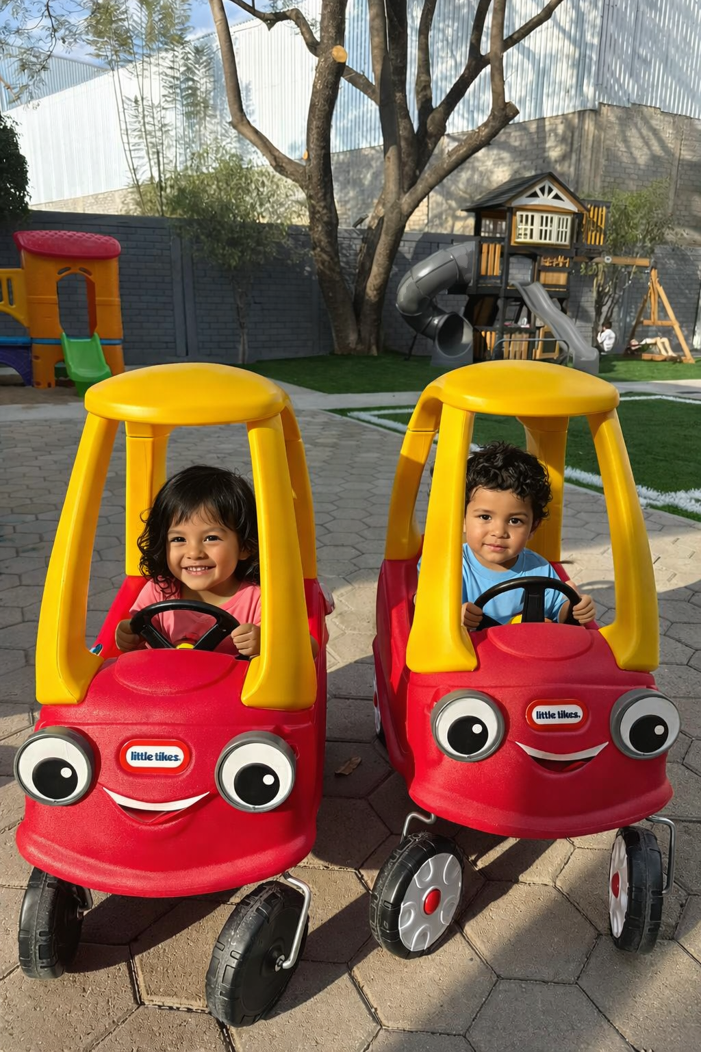 Niños conduciendo carritos infantiles en la pista de autos de Diversitopia, con juegos al fondo.
